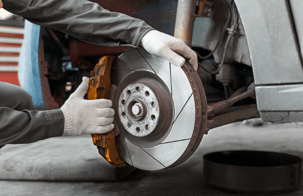 An auto mechanic replacing car breaks with used car parts