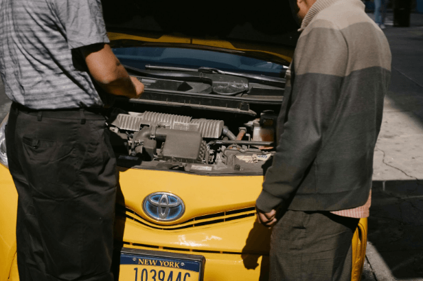 An expert consulting a driver about why used car parts are better than aftermarket