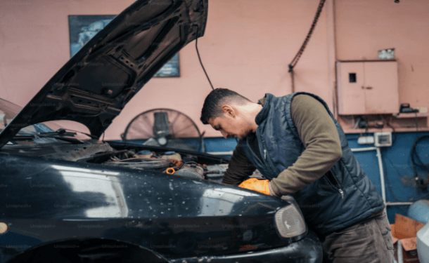 A skilled mechanic installing used car parts in a garage