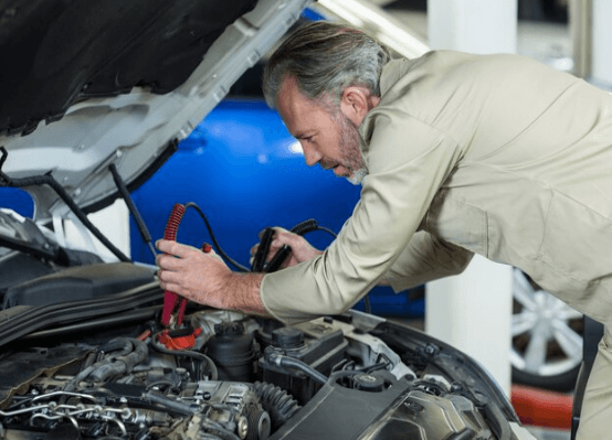 an experienced mechanic working on a damaged car battery